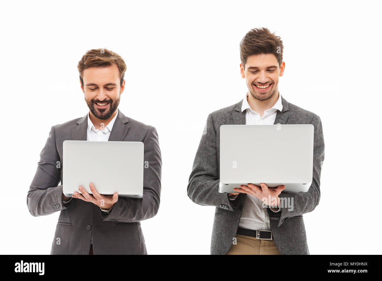 Porträt einer zwei aufgeregt Geschäftsleute mit Laptops auf weißem Hintergrund Stockfoto