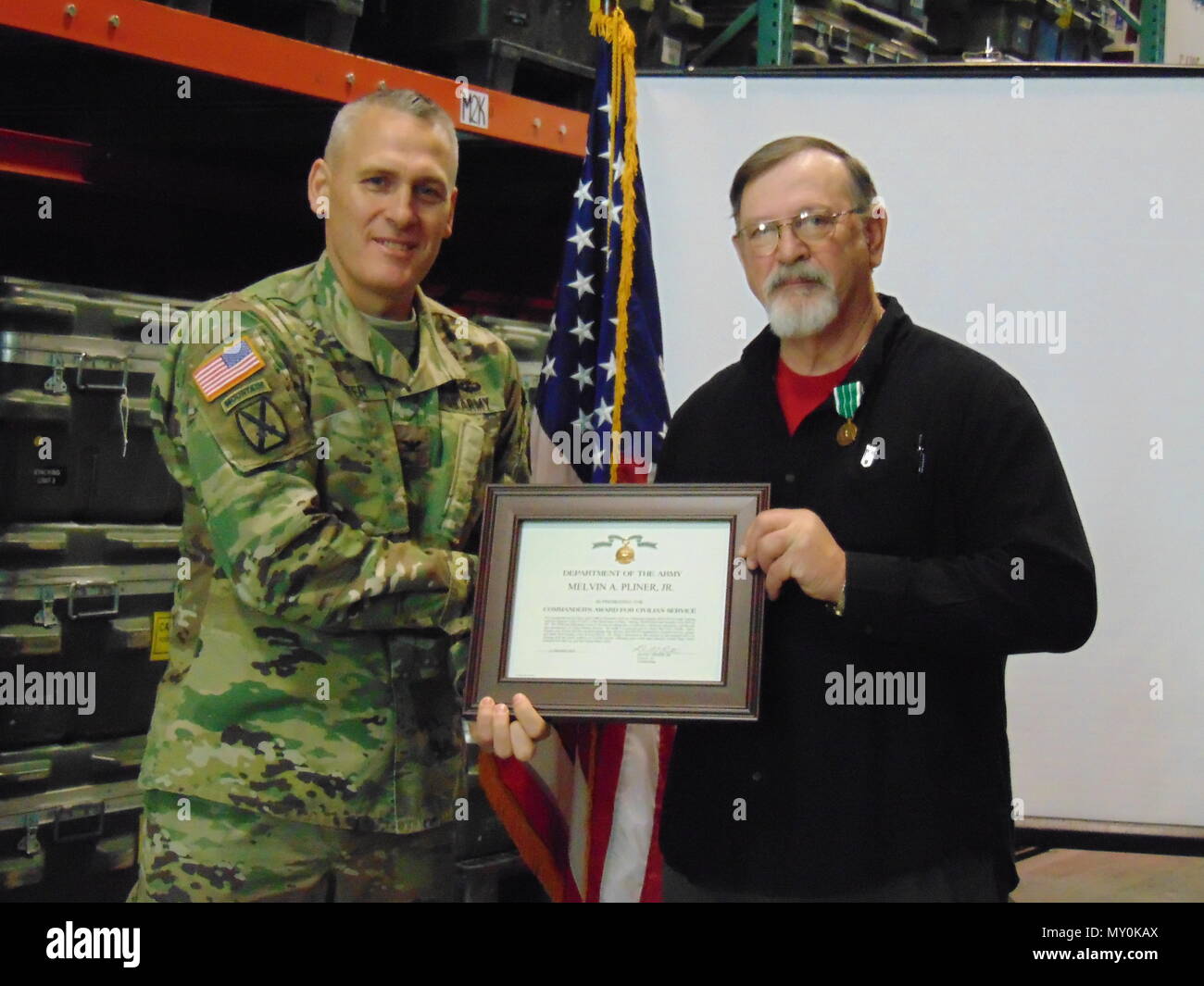 Fort McCoy Garnison Kommandant Oberst David J. Pinter Sr. präsentiert Melvin A. Pliner jr. mit einem Commander Award für Zivildienst im Dezember 2016. Pliner ist ein Bewohner von Tomah, Wis (Foto) beigetragen. Stockfoto