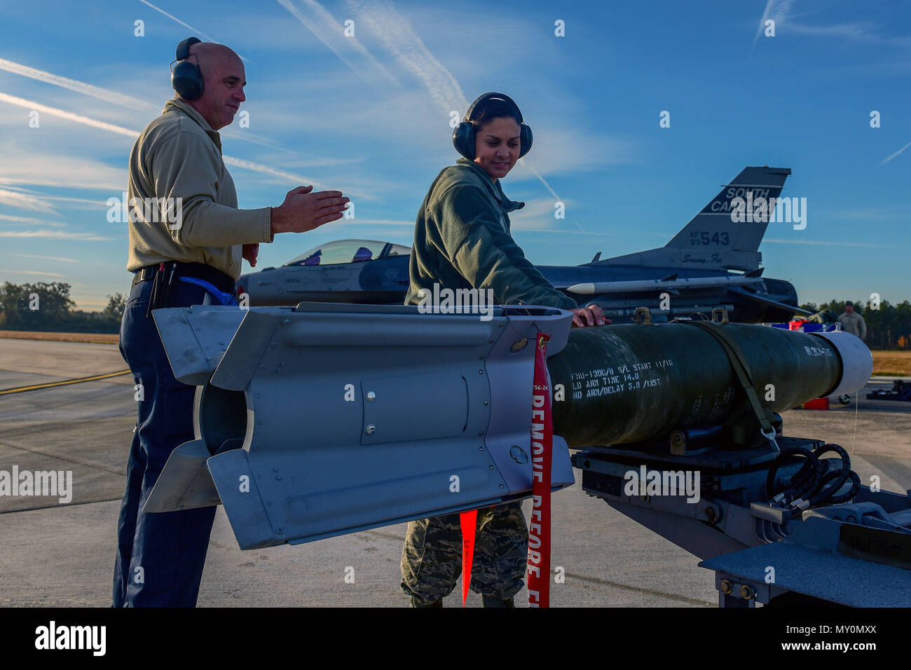 Us Air Force Master Sgt. Roger McKay, Crew Chief, Links, und Senior Airman Sydney Byrd, Waffen, Lader, sowohl für die 169Th Aircraft Maintenance Squadron zugeordnet, bereiten Sie eine Bombe auf dem Rollfeld bei McEntire Joint National Guard Base, South Carolina, Nov. 22, 2016 zu verschieben. Die South Carolina der Air National Guard 169th Fighter Wing ist der einzige Fighter Wing in der Air National Guard, die zu einer stand-alone-Basis zugeordnet ist, die für die Fähigkeit zu speichern, Erstellen, Laden und Live taktischen Inhalte von zu Hause station. (U.S. Air National Guard Foto von Airman 1st Class Megan Floyd) Stockfoto