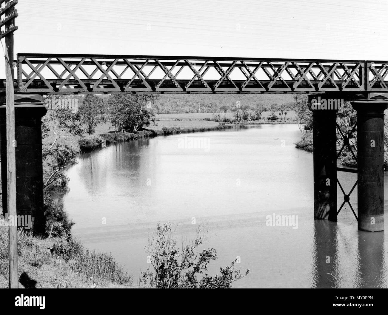 Eisenbahnbrücke über den Albert River, Juni 1952. Die Brisbane Zeiten 24 März 1953 überschwemmt 217248045), wenn die Albert River stieg auf Flut Höhen heute Morgen auf die Ansätze ist, die auf der Seite Yatala wurden schnell fallen, und hielt alle Verkehr in von der Südküste nach Brisbane gebunden. Bild vom nahegelegenen Bahnhof Brücke zeigt den überfluteten Gebiet. Stockfoto