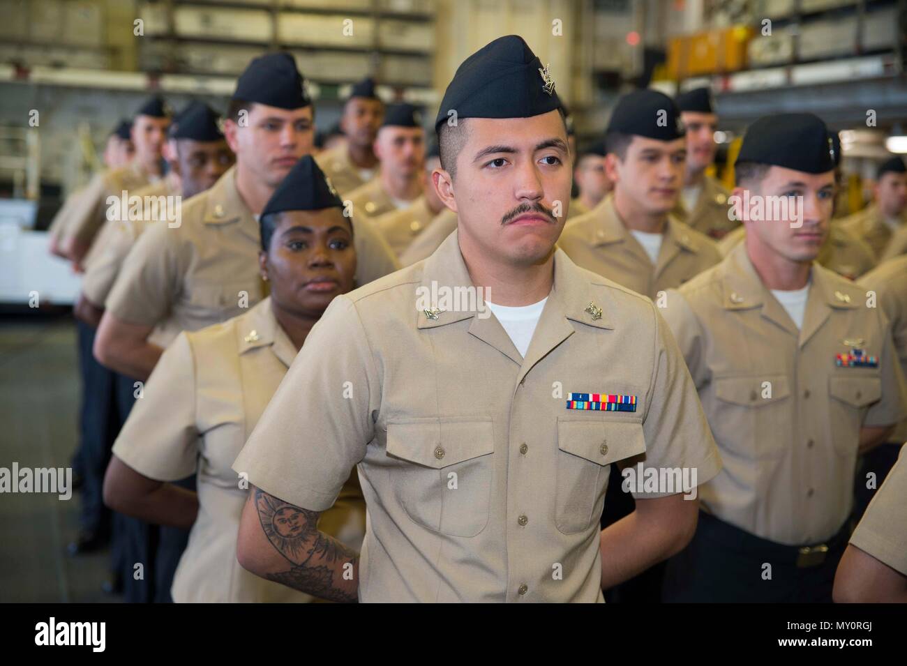 180601-N-XK 809-012 SAN DIEGO (1. Juni 2018) Segler, für die Weiterentwicklung von Petty Officer 2. Klasse ausgewählt, stehen in Ausbildung während eines frocking Zeremonie an Bord des Amphibious Assault ship USS BONHOMME RICHARD (LHD6). Bonhomme Richard ist derzeit in seinen Heimathafen San Diego die Vorbereitung auf eine anstehende geplante Bereitstellung. (U.S. Marine Foto von Mass Communication Specialist 2. Klasse William Sykes) Stockfoto