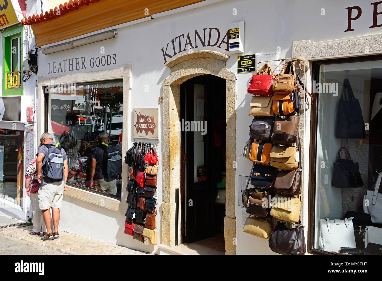 Touristen außerhalb einer Lederwaren Shop in der Altstadt, Albufeira, Portugal, Europa stehen. Stockfoto