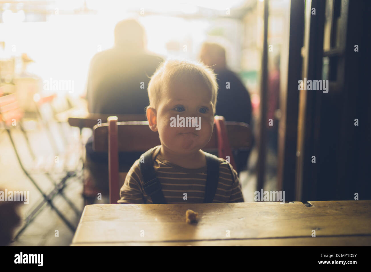 Ein Kleines Baby Sitzt An Einem Tisch In Einem Cafe Und Ist Lernen