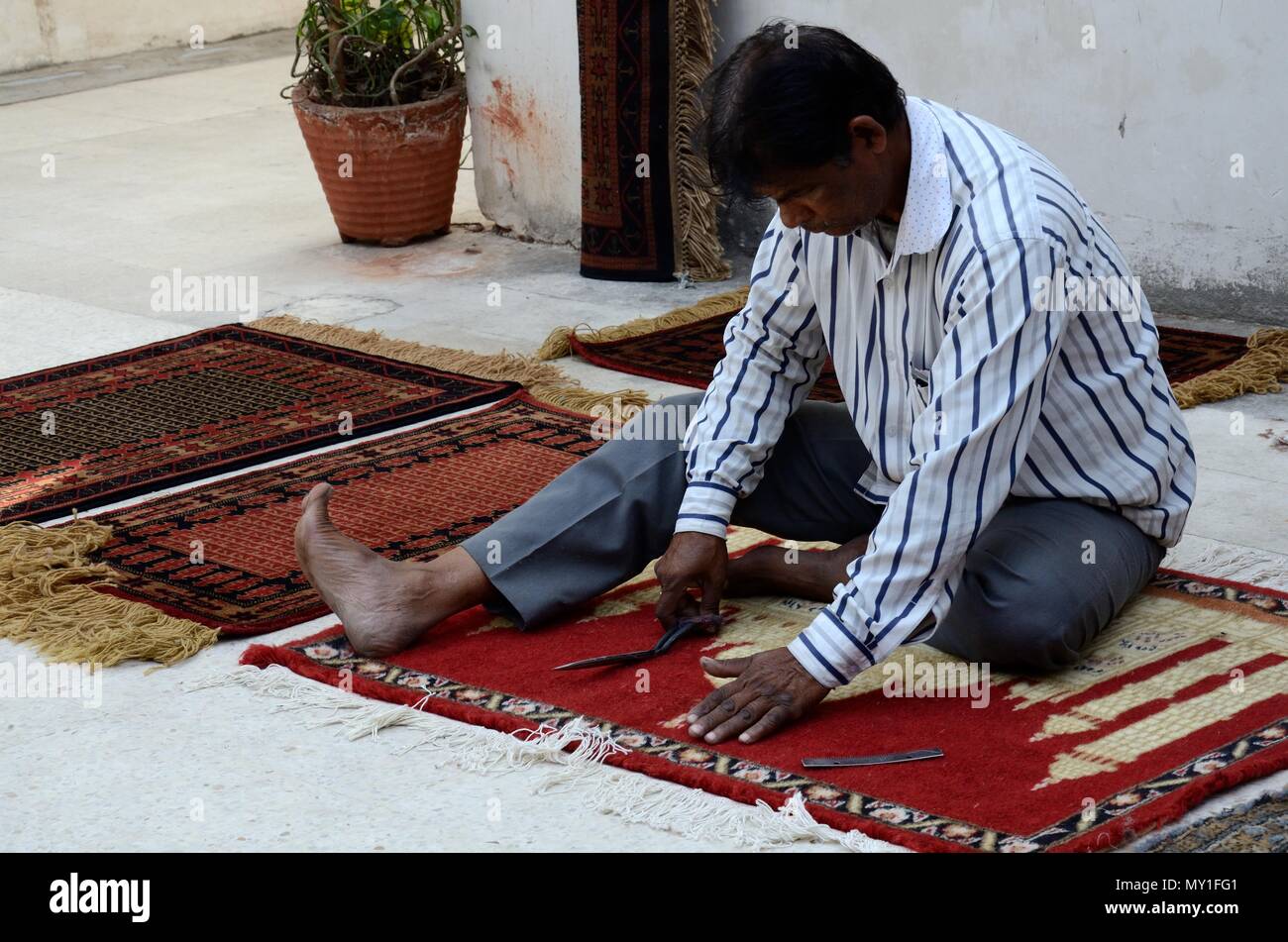 Inder sitzen auf dem Boden, den letzten Schliff zu einer Hand tauchte reg Jaipur Indien Rajashan Stockfoto