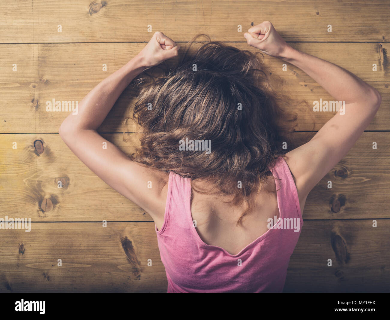 Verärgert Frau mit geballten Fäusten an einem Holztisch Stockfoto
