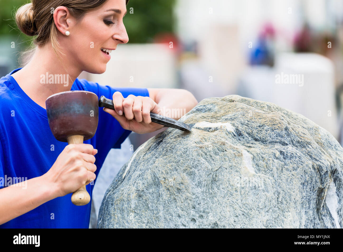 Steinmetz arbeiten auf Boulder mit sledgehammer und Bügeleisen Stockfoto