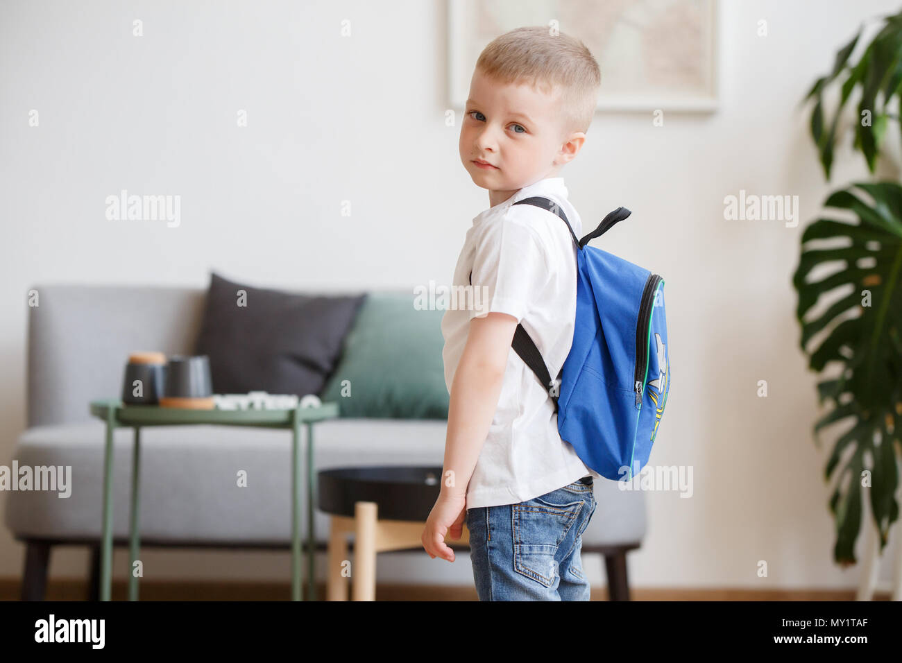 Bild von Jungen mit Rucksack in der Nähe von sofa Stockfoto