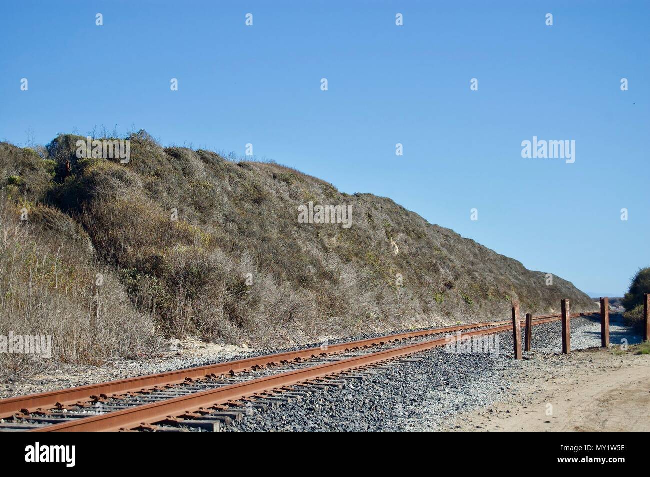 Einsamen verlassenen Bahngleisen von einem schönen Küsten, in Kalifornien (USA) mit Kalkstein Felsen, viel Grün und den Pazifischen Ozean umgeben Stockfoto