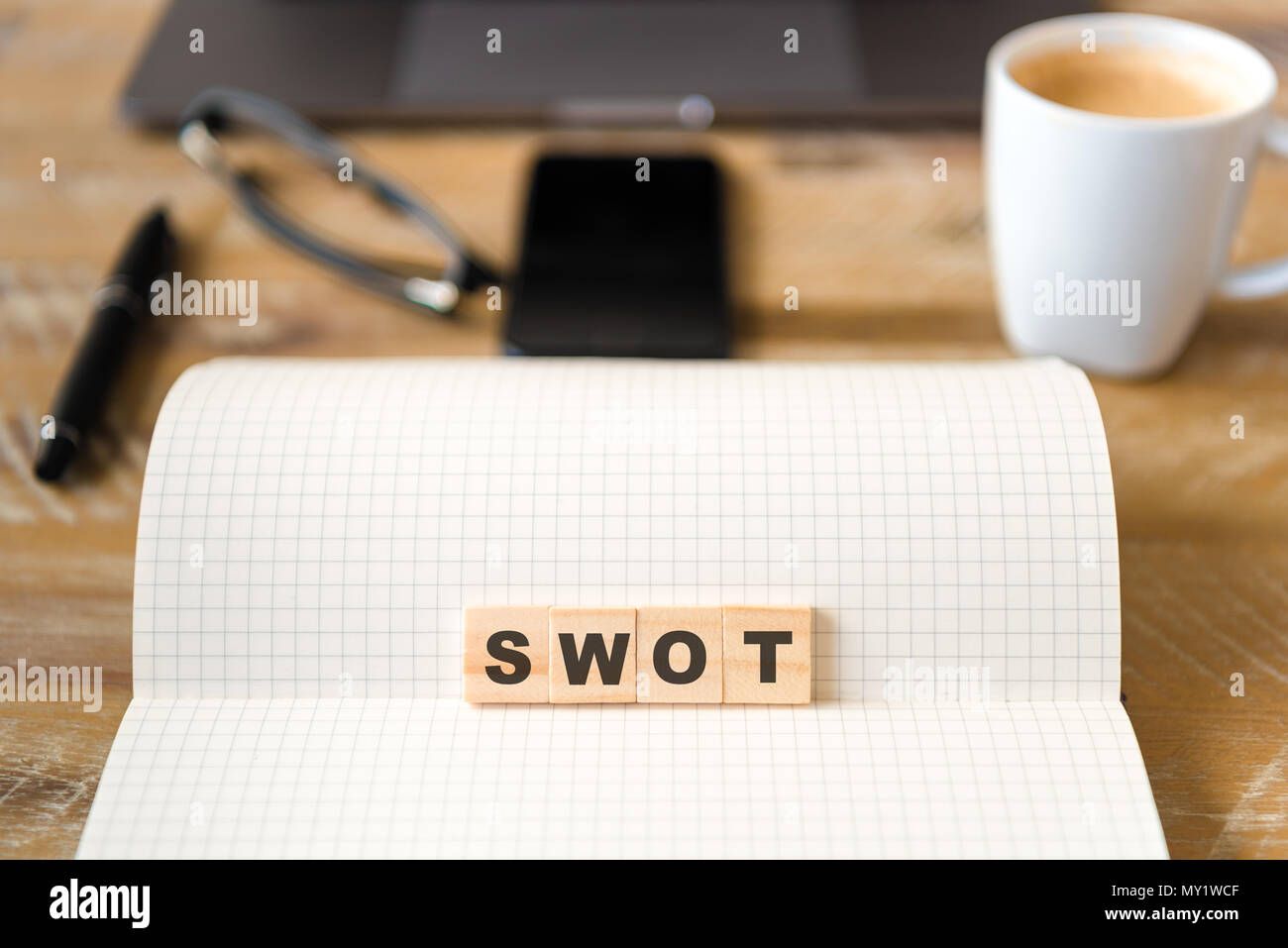 Nahaufnahme auf das Notebook um Holz Tisch Hintergrund, auf Holzblöcken mit Buchstaben, SWOT-Analyse Text konzentrieren. Stockfoto