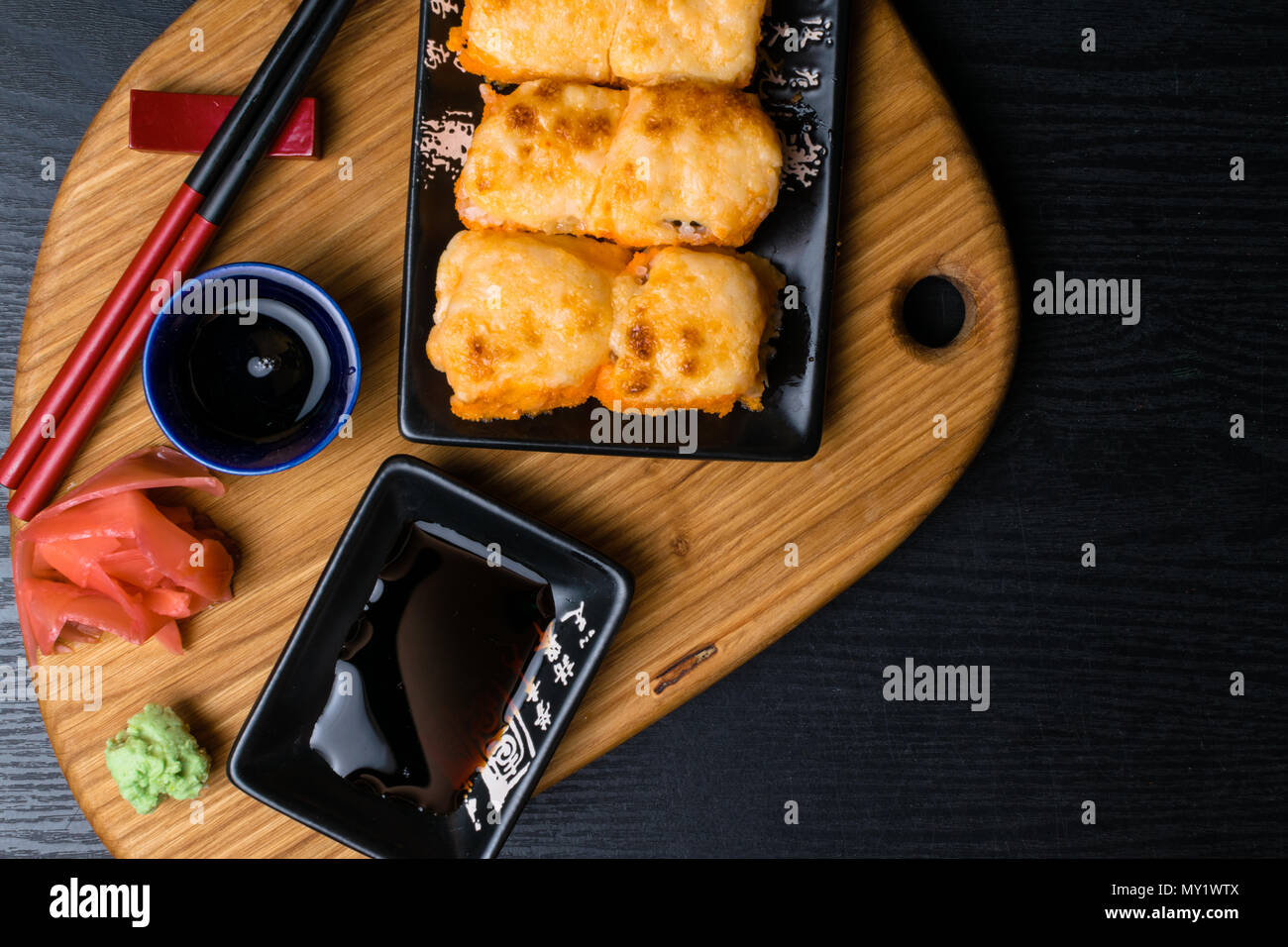 Heißes gebratenes Sushi Roll mit Lachs, Kaviar, Garnelen, Gurke, Avokado, Käse. Sushi Menü. Japanisches Essen mit Wasabi, Ingwer, soy souce. Heißes gebratenes Sushi Stockfoto