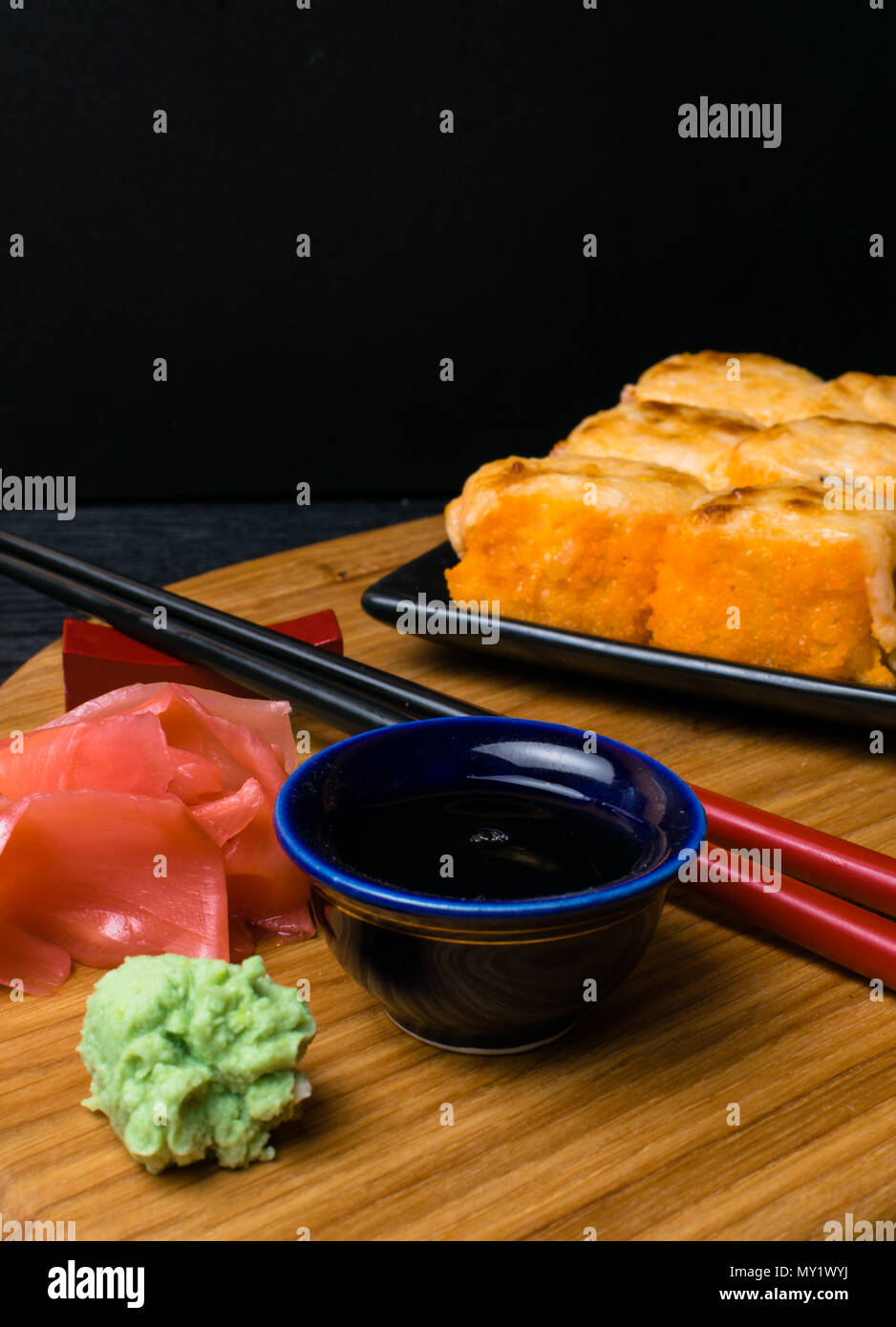 Heißes gebratenes Sushi Roll mit Lachs, Kaviar, Garnelen, Gurke, Avokado, Käse. Sushi Menü. Japanisches Essen mit Wasabi, Ingwer, soy souce. Heißes gebratenes Sushi Stockfoto