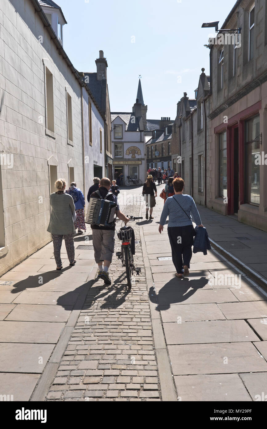 Dh Stromness Folk Festival STROMNESS ORKNEY Akkordeon Musiker Fahrrad die Straße Menschen Schottland Stockfoto
