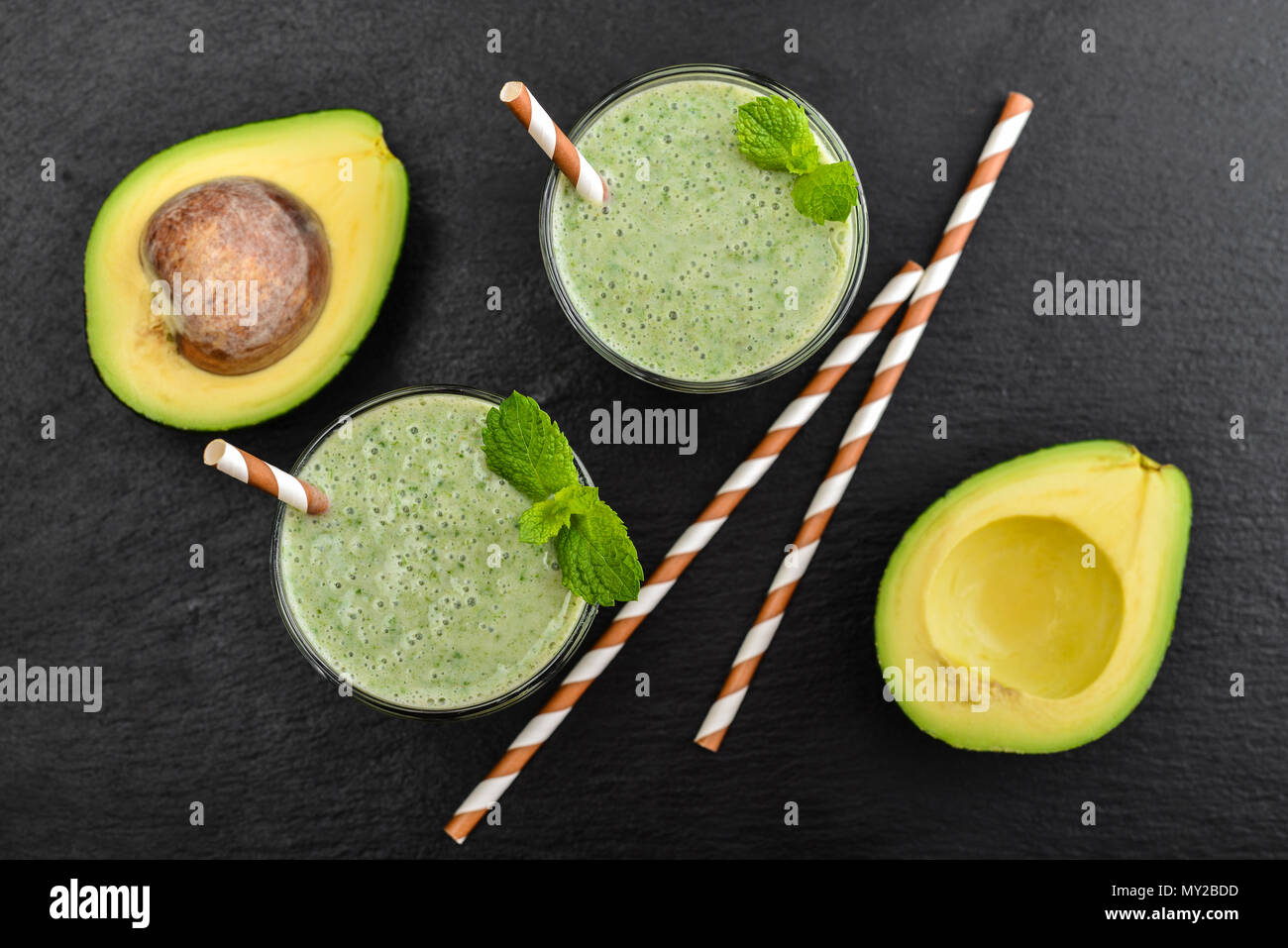 Frische avocado Smoothie mit Kalk und Sellerie auf schwarzem Schiefer Hintergrund, Ansicht von oben Stockfoto