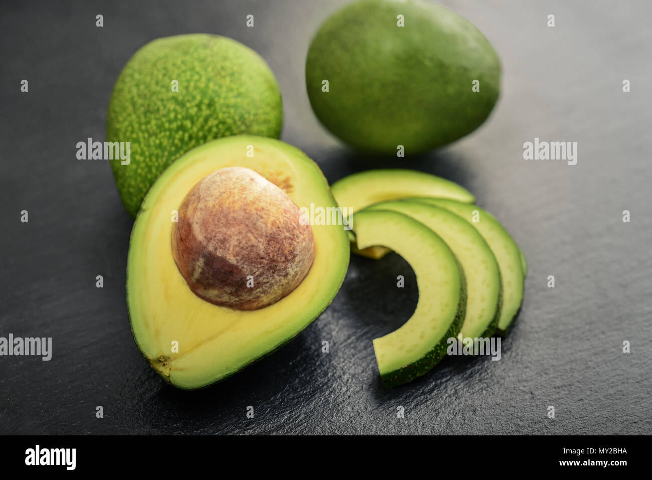 Frische avocado über schwarzem Schiefer Hintergrund Stockfoto