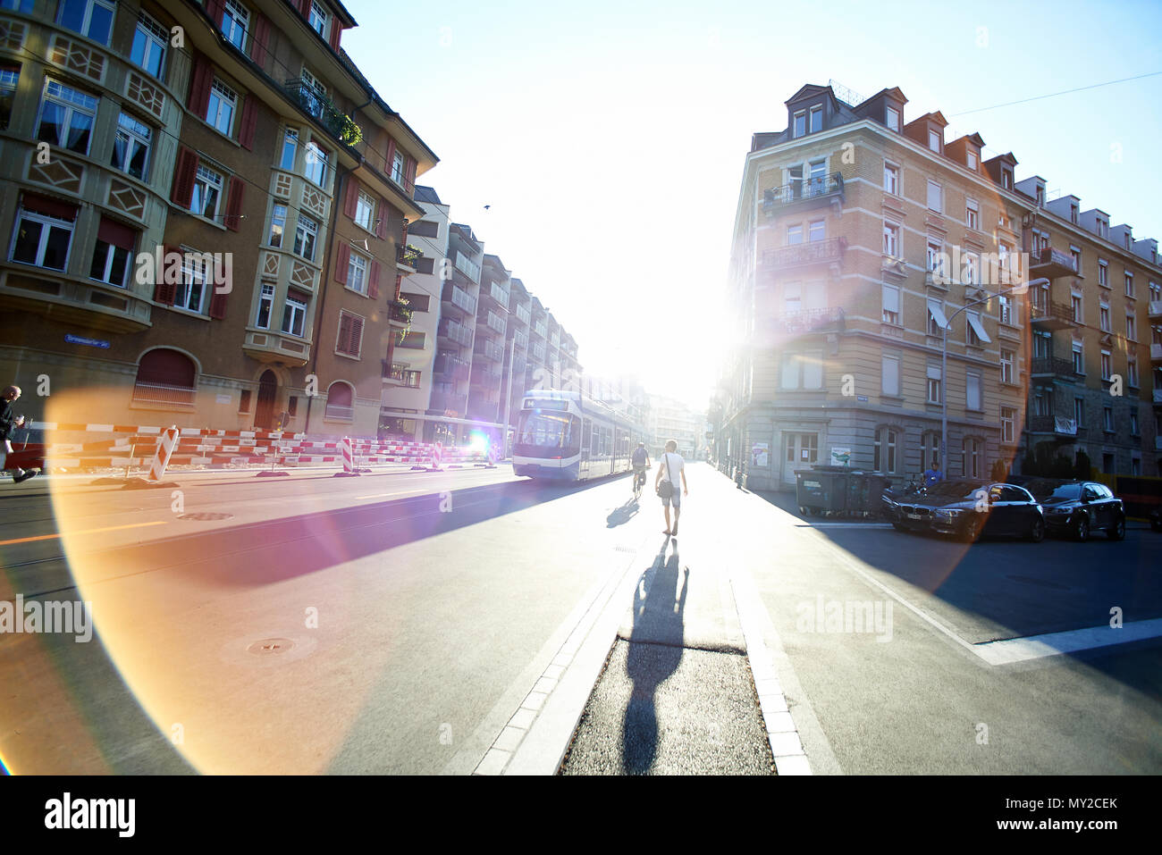 Sicht Bild eines Mannes und am frühen Morgen die Pendler die Straßenbahn im hellen Sonnenschein am frühen Morgen hetzen die Straßenbahn zum Büro zu fangen Stockfoto
