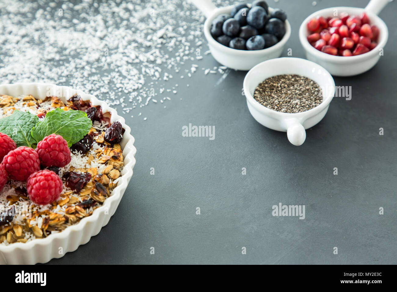 Sweet vegane Nachspeise von Samen und Früchten sowie einem verschwommenen Hintergrund mit Zutaten für eine Torte Stockfoto