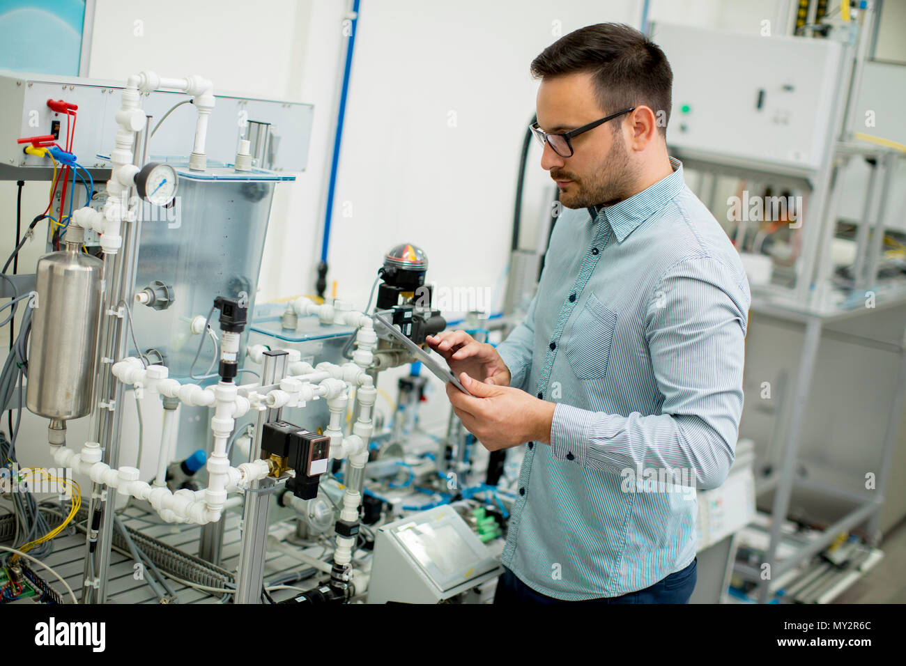 Hübscher junger Mann, der in der elektronischen Werkstatt Stockfoto