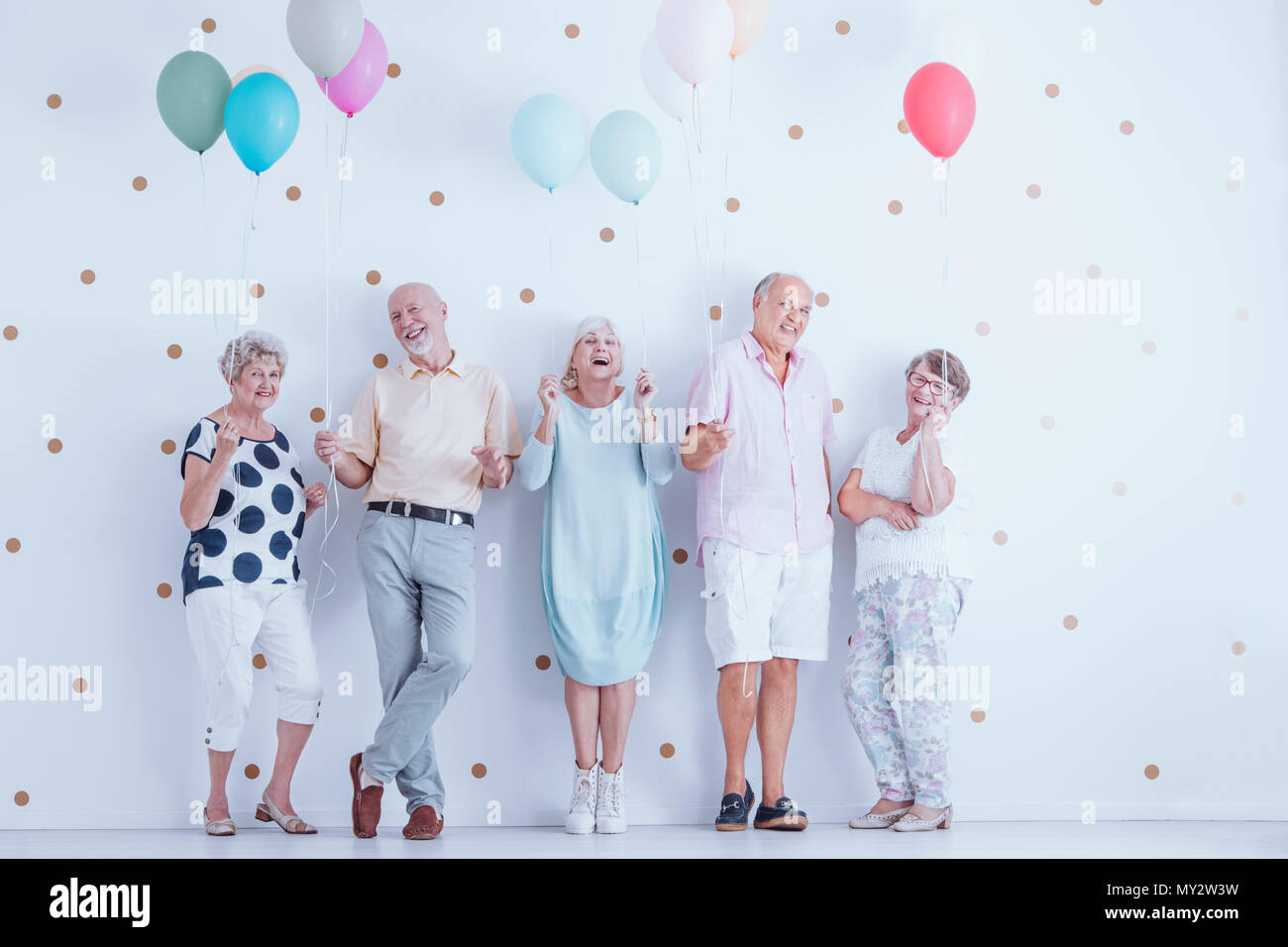 Gerne ältere Menschen mit bunten Luftballons feiern Geburtstag des Freundes Stockfoto