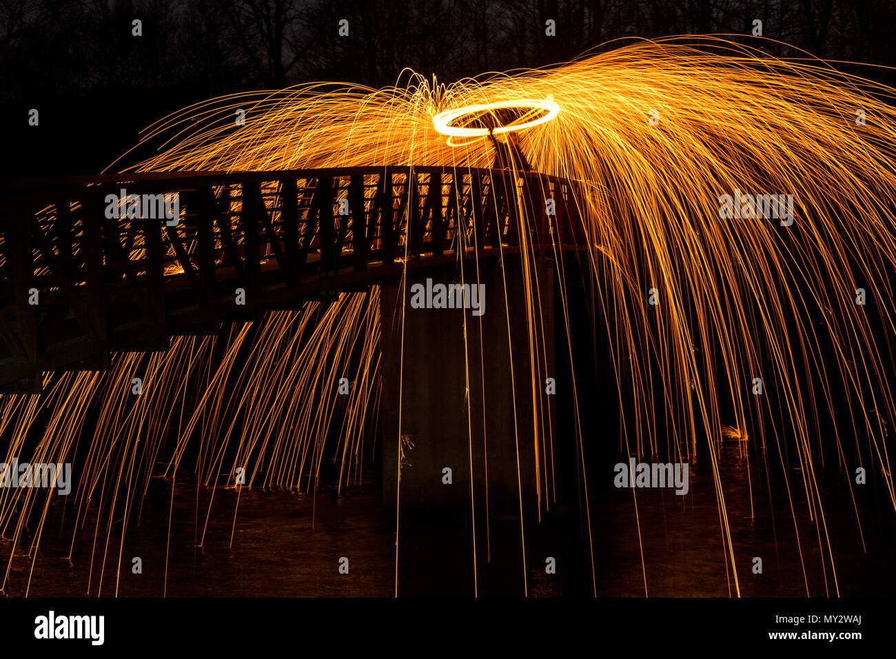 Licht Malerei bei Nacht wirbelnden Stahlwolle brennen am Ende eines Seils. Stockfoto