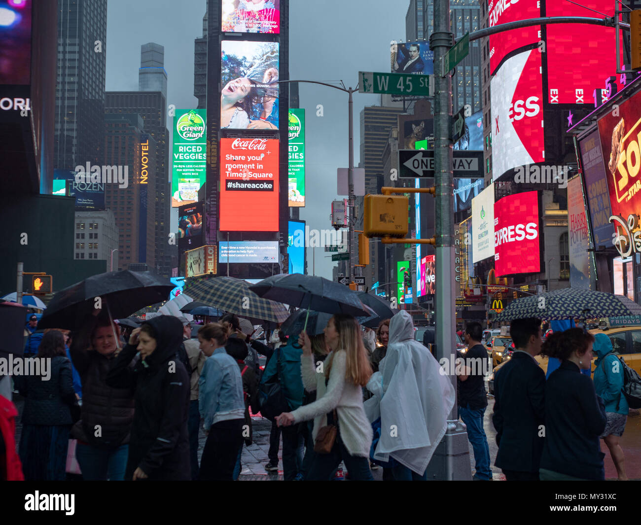 NEW YORK, NY - 16. MAI 2018: Touristen erkunden Times Square während Ausweichen Regen Stockfoto