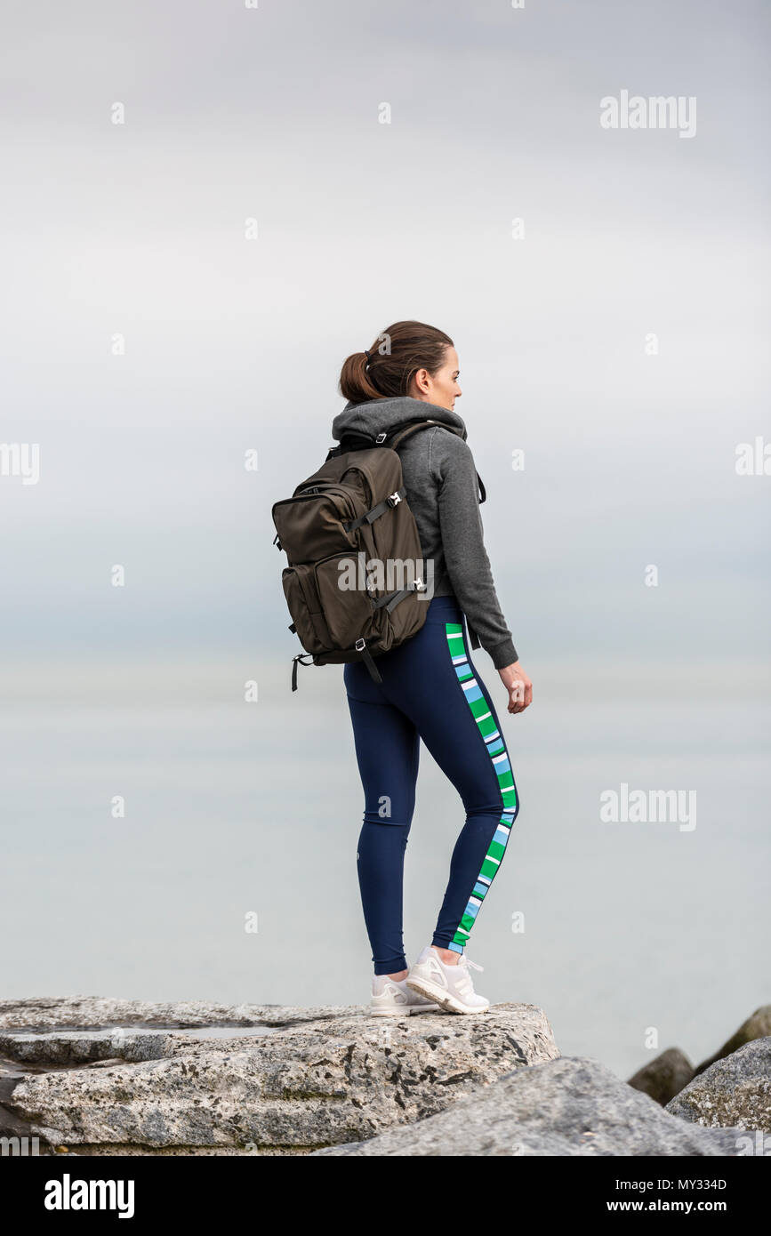 Frau Wanderer auf Felsen trägt einen Rucksack Stockfoto