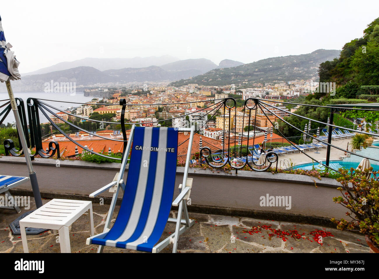 Ein blau-weiß gestreiften Liegestuhl mit Blick auf die Bucht von Neapel im Hintergrund im Grand Hotel Capodimonte, Sorrento, Italien Stockfoto