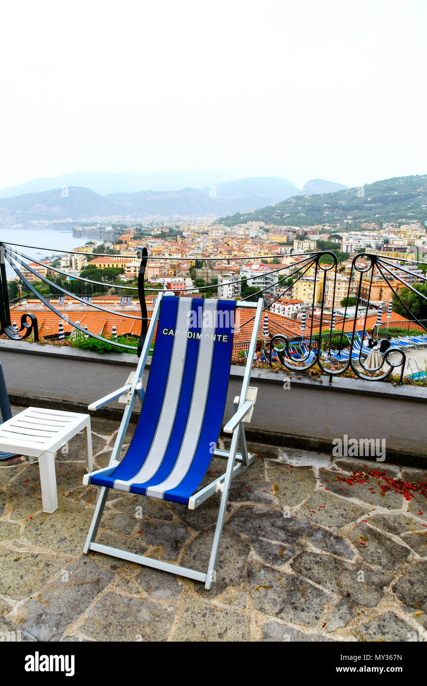 Ein blau-weiß gestreiften Liegestuhl mit Blick auf die Bucht von Neapel im Hintergrund im Grand Hotel Capodimonte, Sorrento, Italien Stockfoto