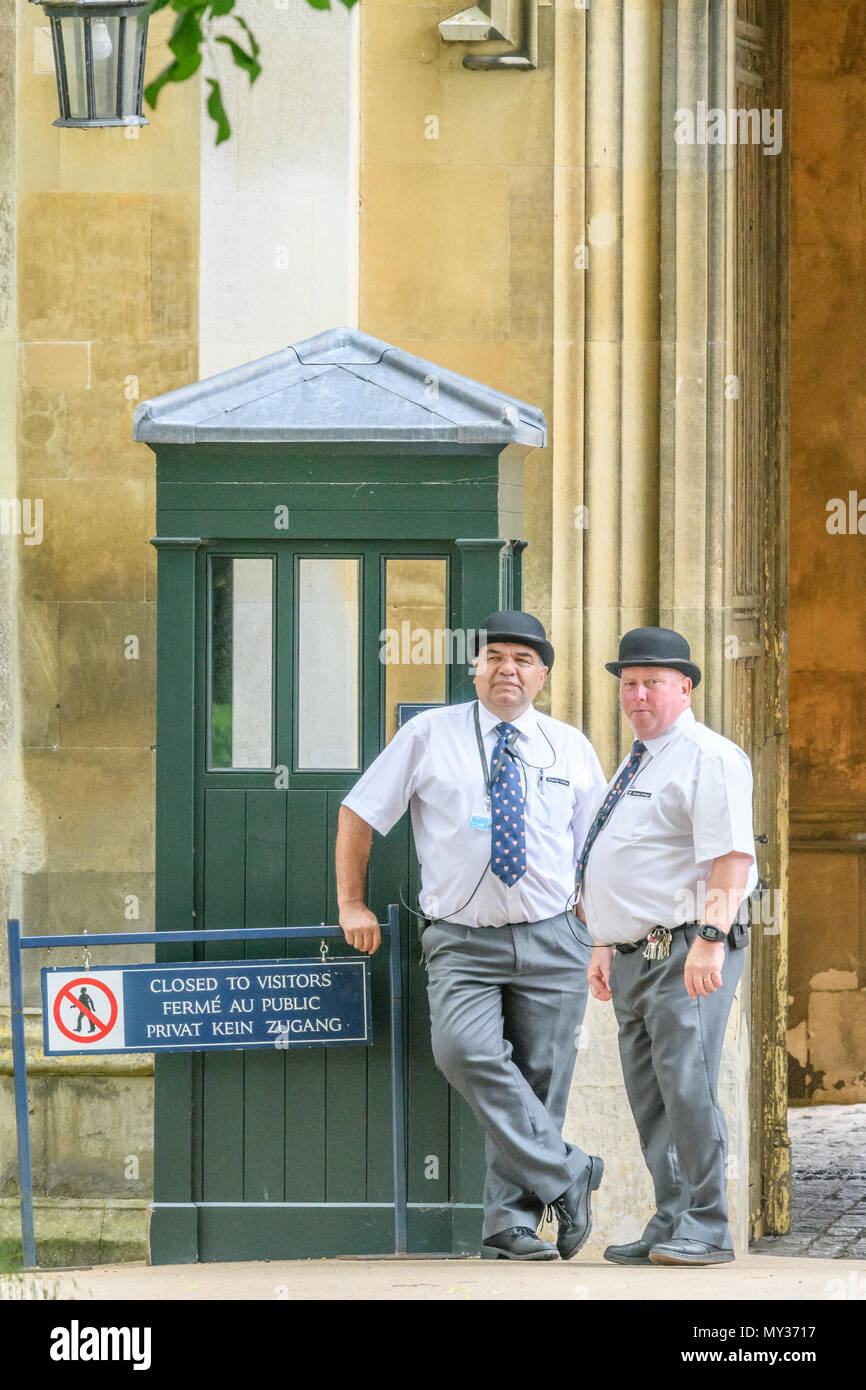 Ein paar kräftige männliche, Bowler hatted Sicherheitsleute stehen auf Pflicht durch den Eintritt in Neue (aka King's) Gericht am Trinity College der Universität von Cambri Stockfoto