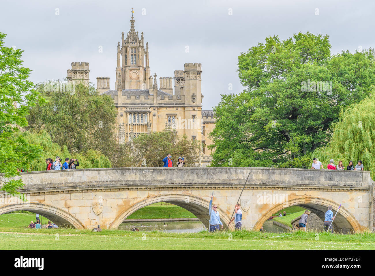 Touristen nehmen Fotos von Trinity Bridge, während andere entlang des Flusses Cam neben Trinity College der Universität Cambridge, England, mit dem Hl. Johannes Punt Stockfoto