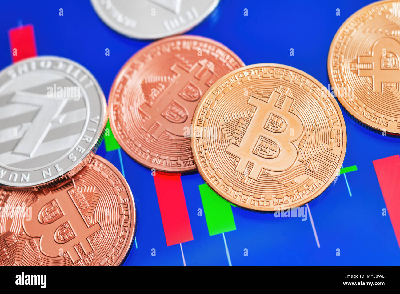 Cryptocurrency Bitcoin und Litecoin Münzen über Tablet Bildschirm mit candlestick Chart. Stockfoto