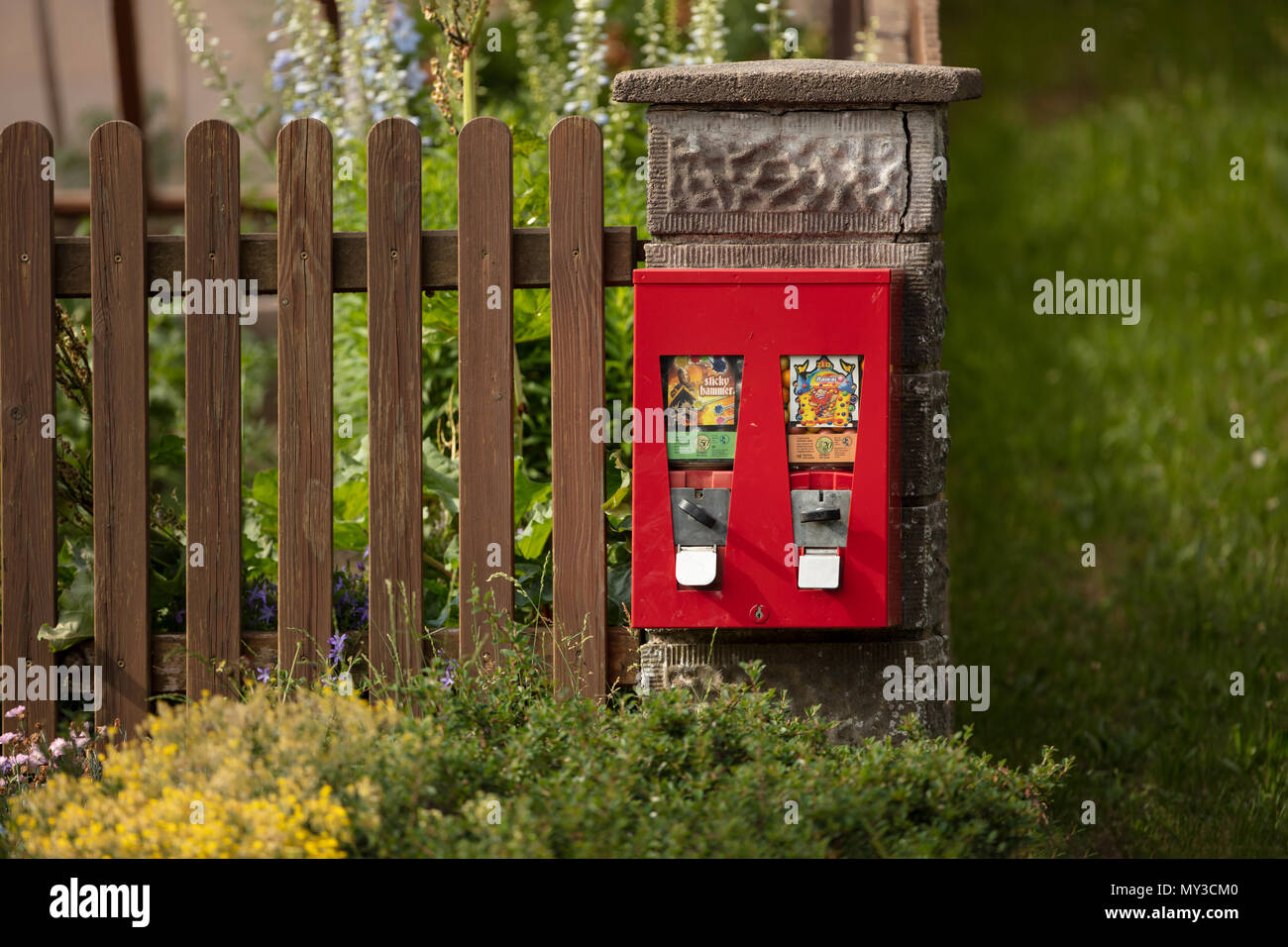 Red double gumball Machine an den Pfosten ein Zaun um ein eigenes Grundstück in Beyerberg, Deutschland Stockfoto
