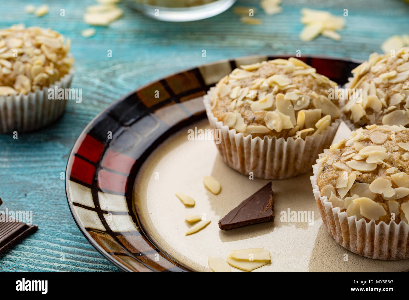 Leckere Muffins mit Zucker Mandeln, Walnüsse und Schokolade auf Blau Holz- Hintergrund Stockfoto