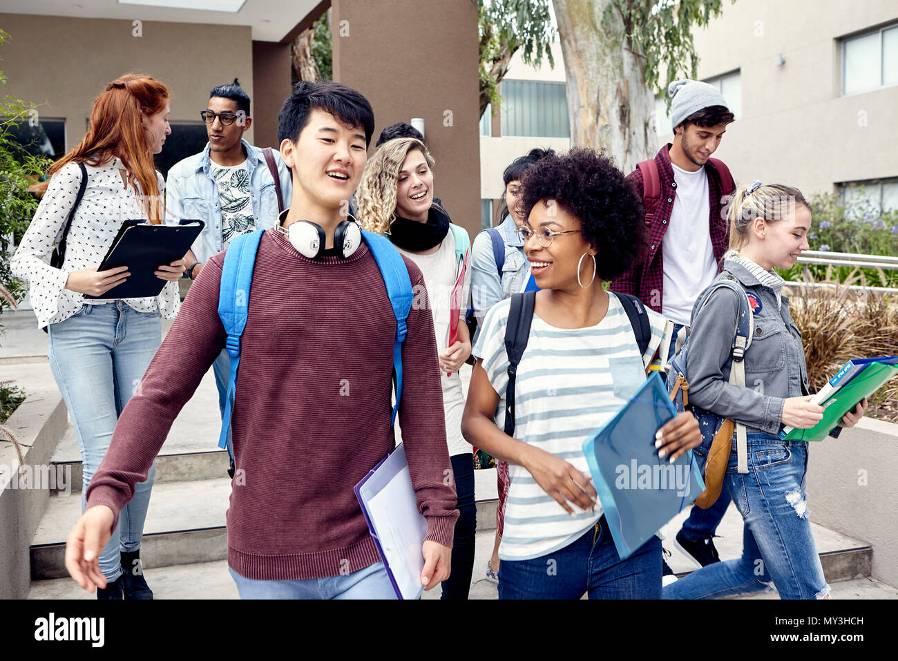 Studenten gehen und zusammen plaudern auf dem Campus Stockfoto