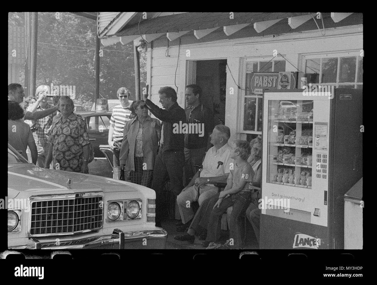 Präsidentschaftskandidat Jimmy Carter (Winken, Mitte) macht eine Kampagne Stop an der Tankstelle seinen Bruder Billy Carters in ihrer Heimatstadt, Ebenen, GA, 9/10/1976. Foto von Thomas O'Halloran Stockfoto