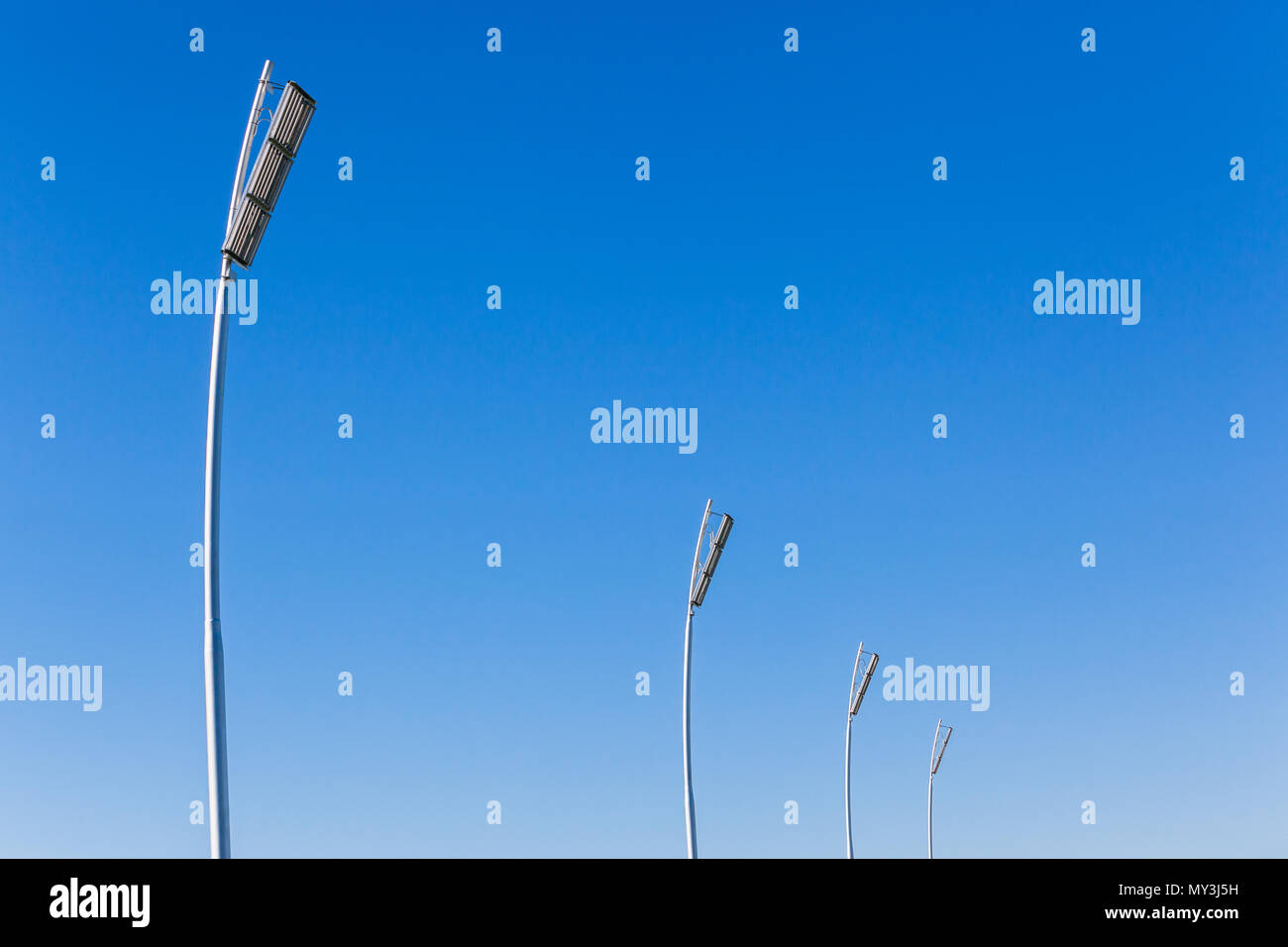 Vier neue elektrische Flutlicht Türme mit leistungsstarken Leds für Nacht Ereignisse über Sportplatz im blauen Himmel. Stockfoto