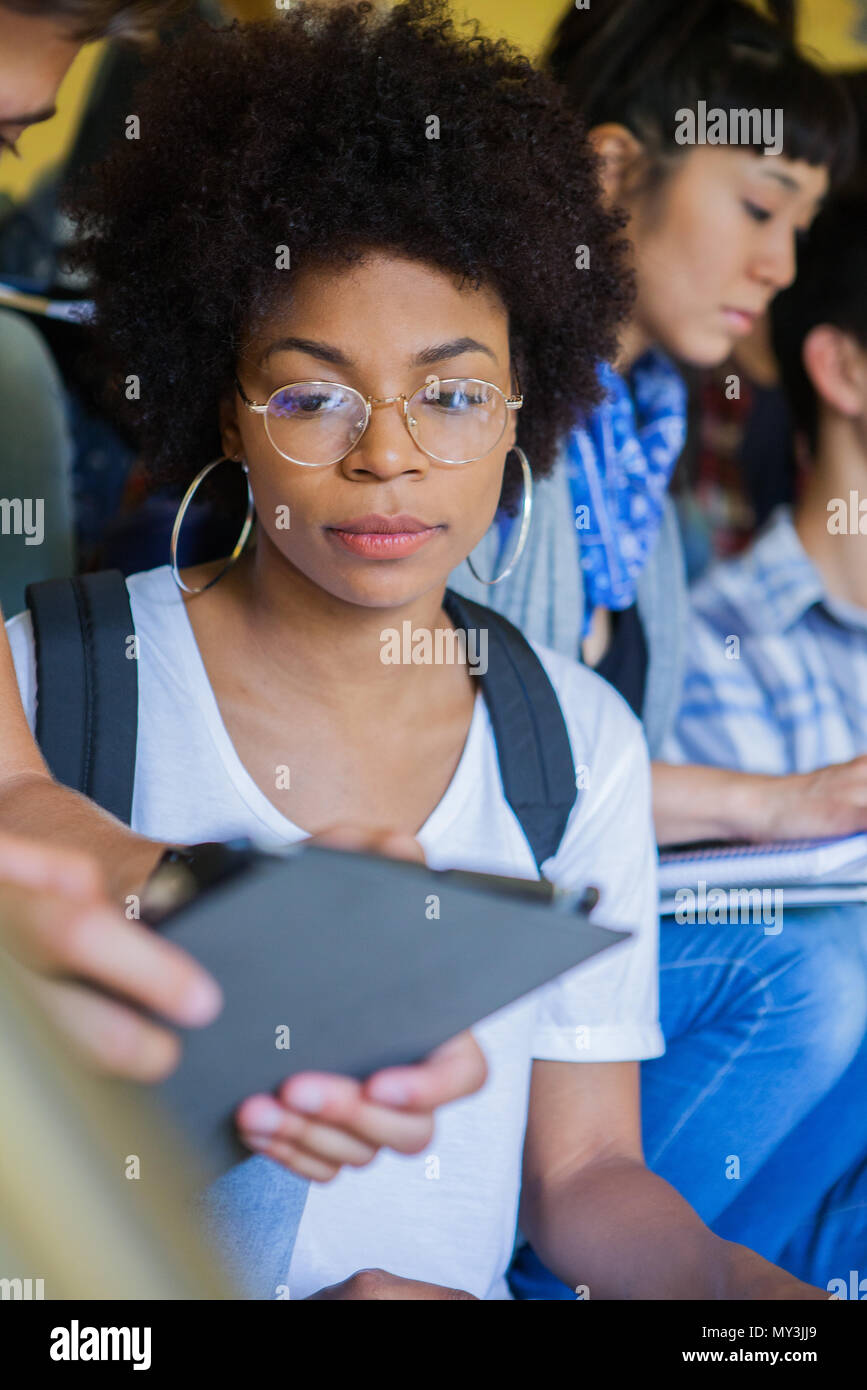 Student an Mitschüler digital Tablet suchen Stockfoto