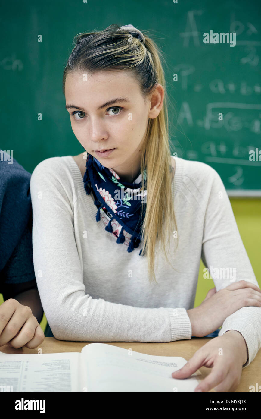Junge Frau sitzt in der Klasse Math, Porträt Stockfoto
