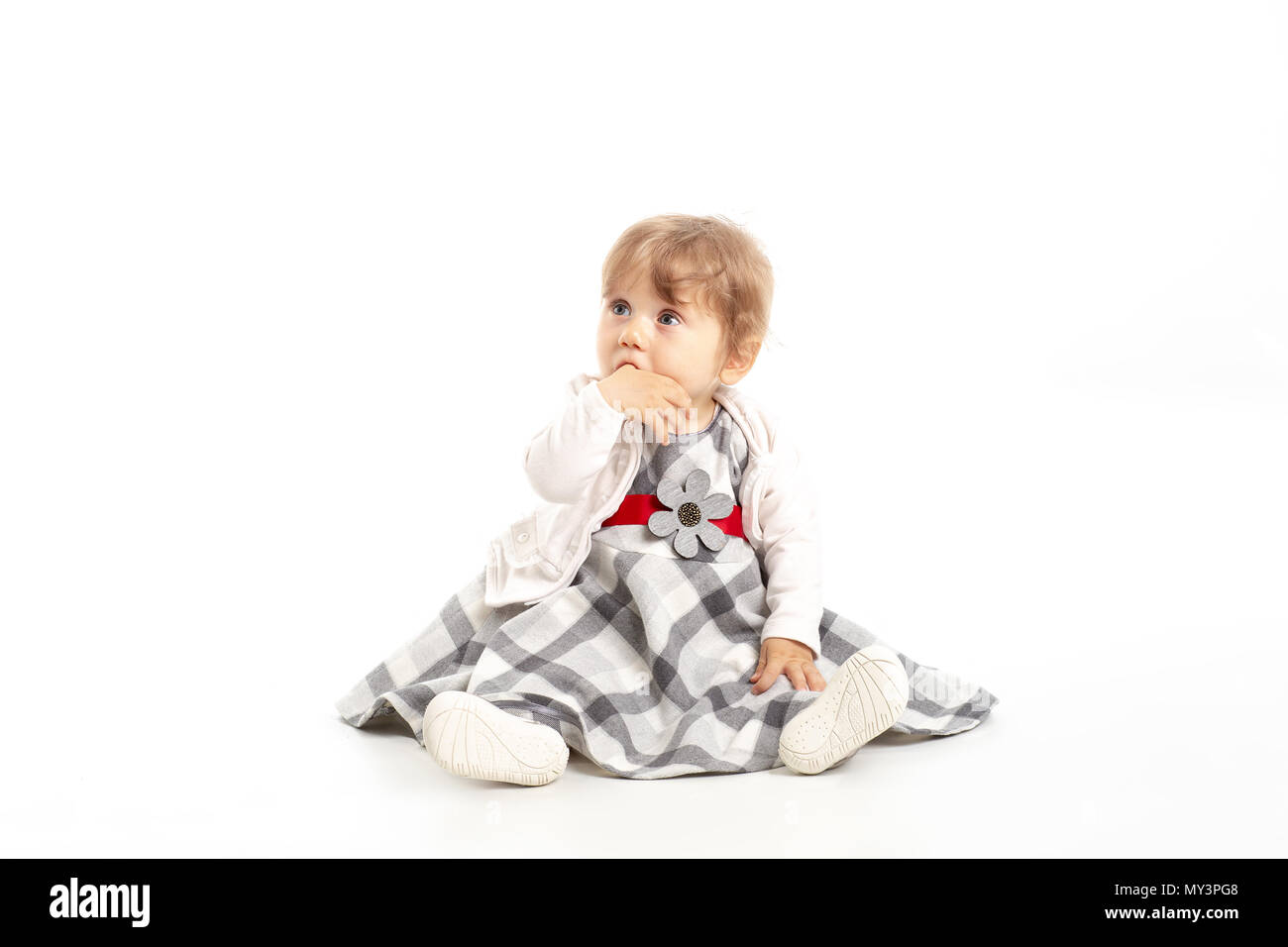Elegante Happy Baby girl 1 Jahr alt sitzen auf dem Studio. Weißer Hintergrund. Konzept Das Glück. Stockfoto