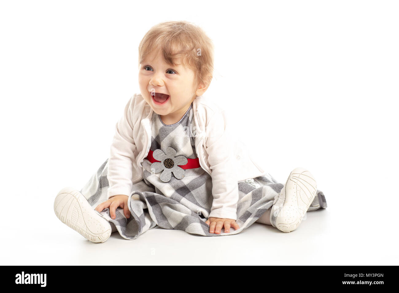 Elegante Happy Baby girl 1 Jahr alt sitzen auf dem Studio. Weißer Hintergrund. Konzept Das Glück. Stockfoto