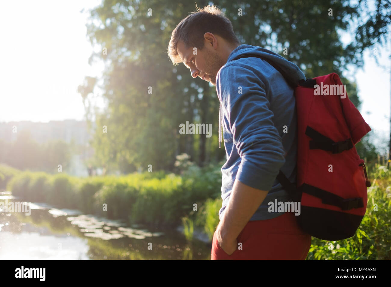 Mann mit roten Rucksack wandern in Wald in der Nähe des Flusses allein. Stockfoto