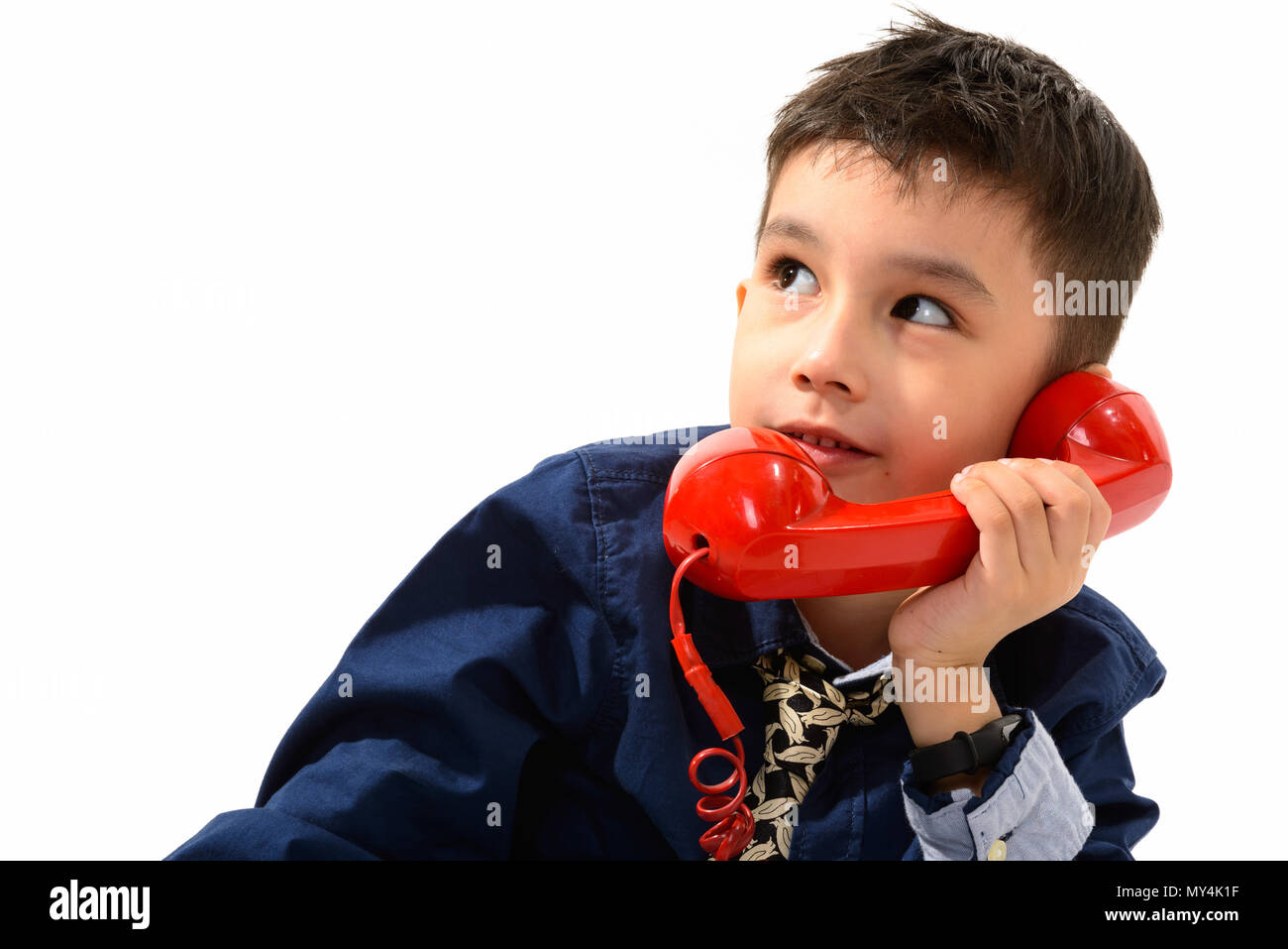 Studio shot der netten Jungen sprechen auf alten Telefon beim Denken Stockfoto