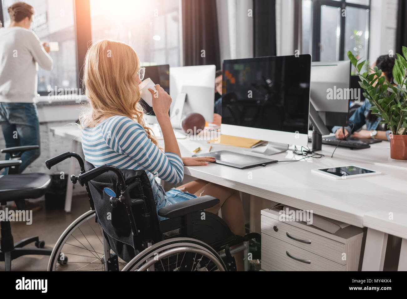 Incapacitated Person im Rollstuhl im modernen Büro arbeiten Stockfoto