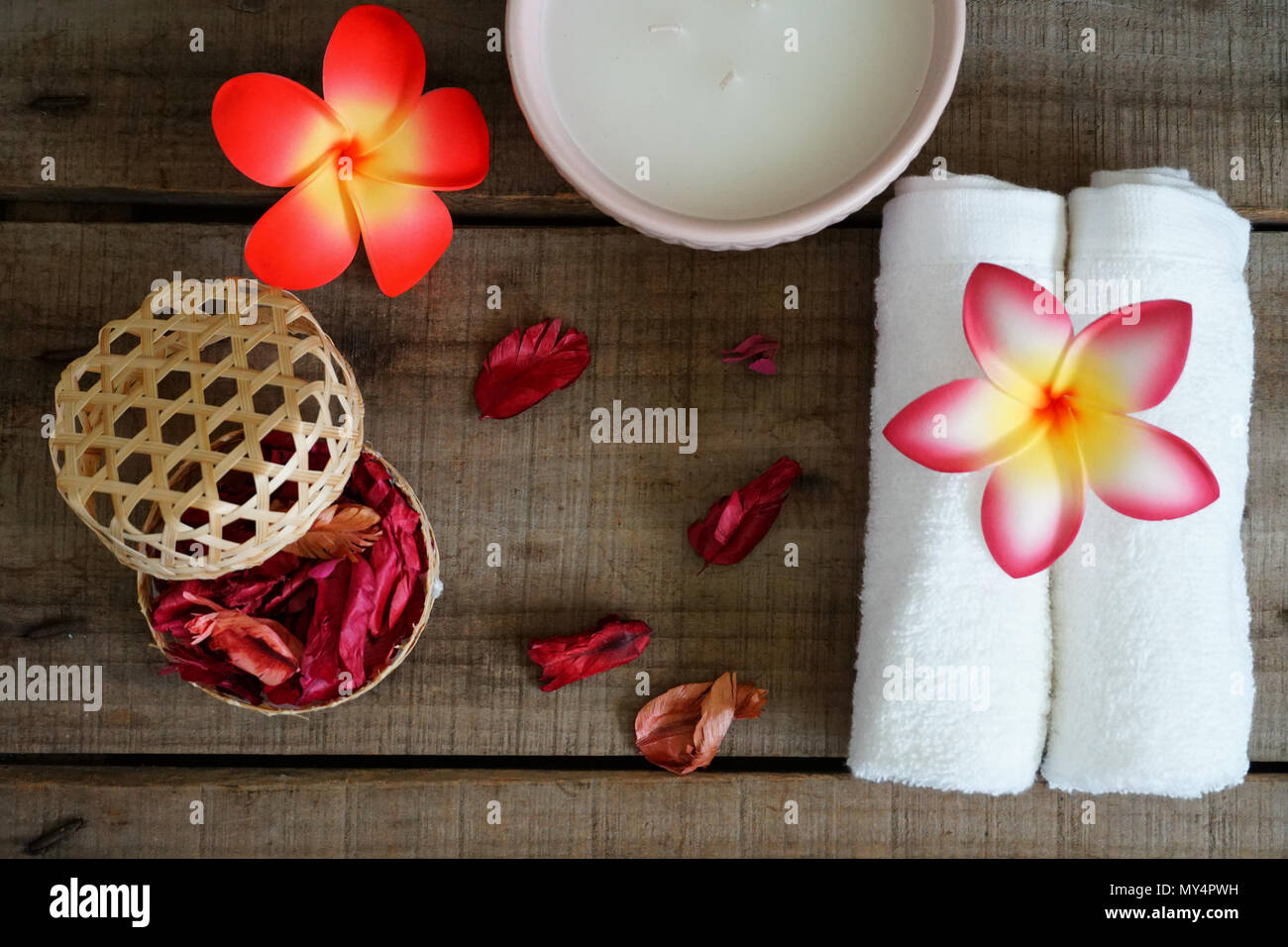 Weiße Handtücher schmücken mit Orange Blume in der Nähe von trockenen Duft Rose auf Spa Set Table. Stockfoto
