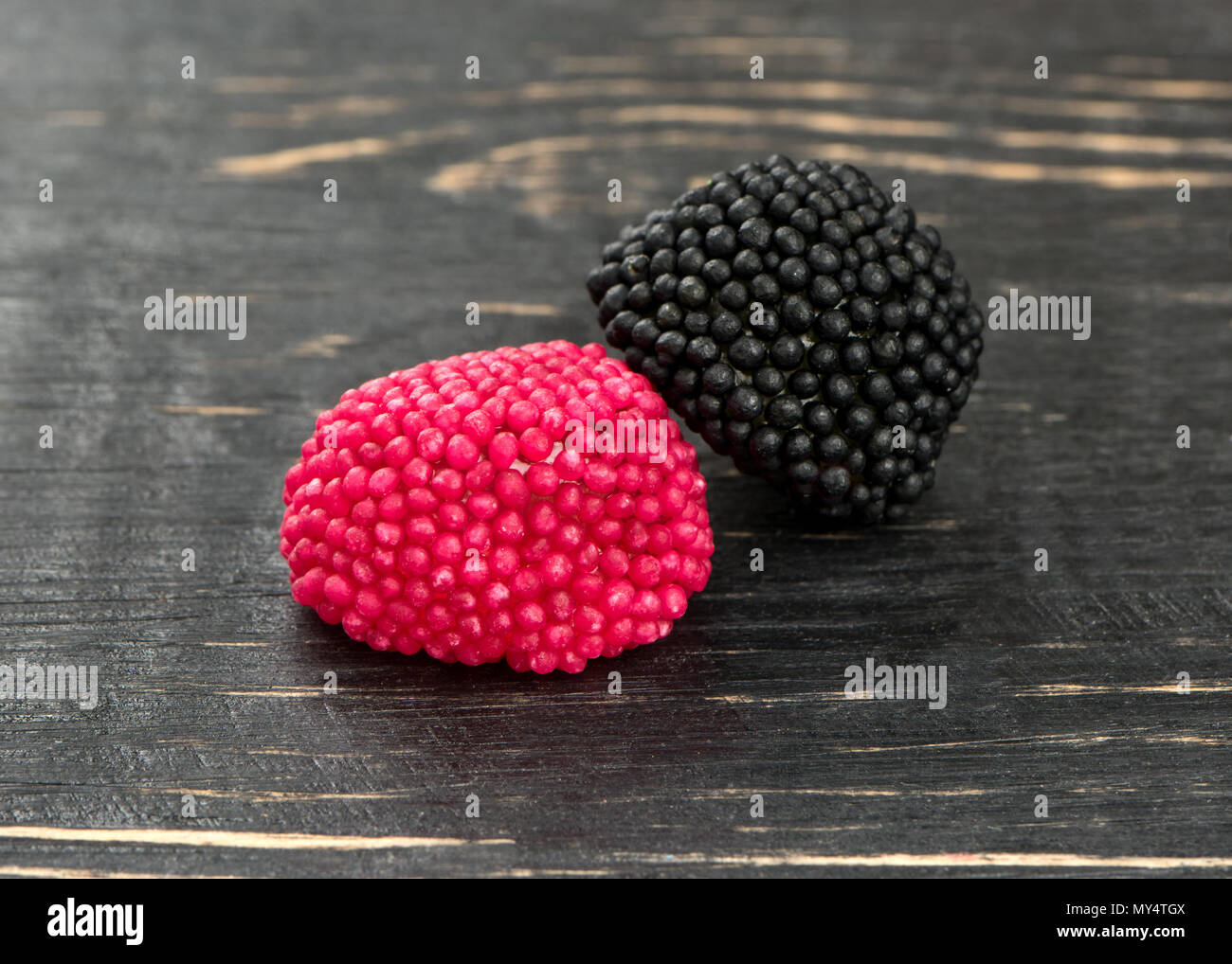 Schwarz und Rot berry jelly Candy auf einer hölzernen Hintergrund Stockfoto