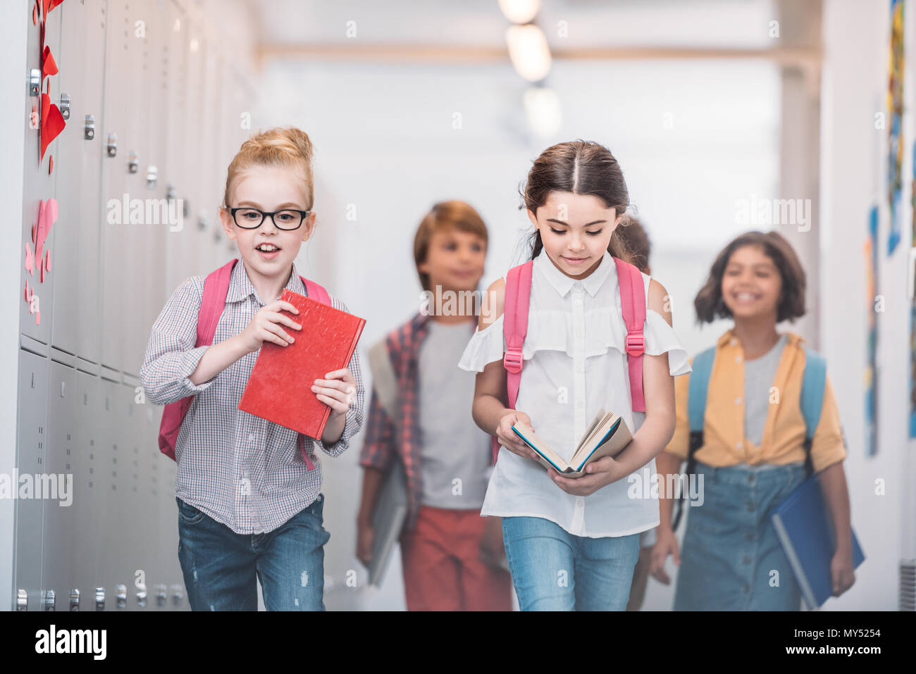 Die Schülerinnen gehen in der Klasse durch Schule Korridor Stockfoto