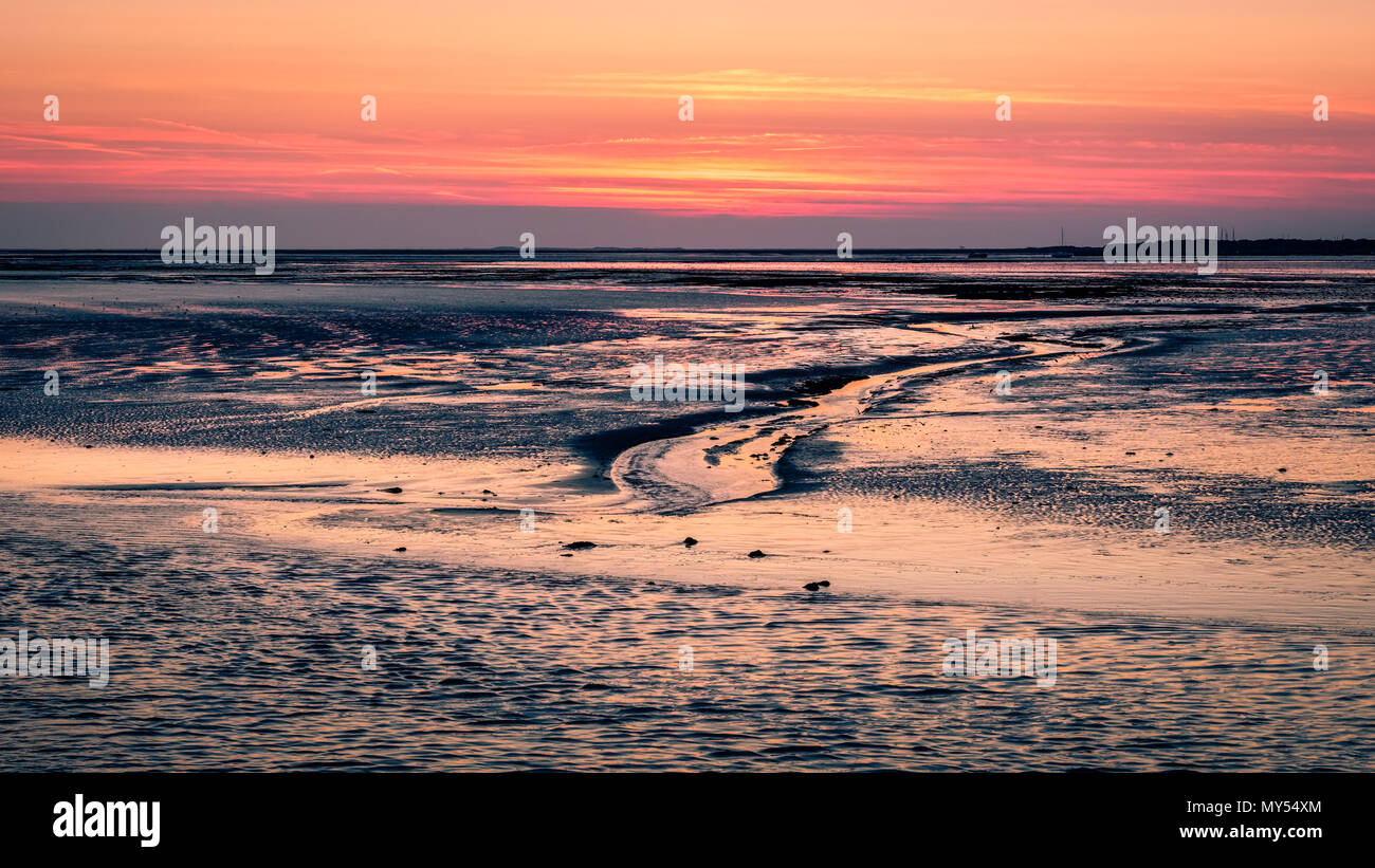 Der Himmel wird purpurrot, nach Sonnenuntergang, wenn die Fähre hat der Hafen der Insel Schiermonnikoog für Lauwersoog auf dem Festland links Stockfoto