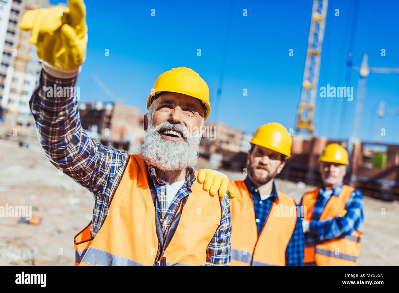 Foreman, der seinen Finger und etwas zu zeigen Arbeiter auf der Baustelle Stockfoto