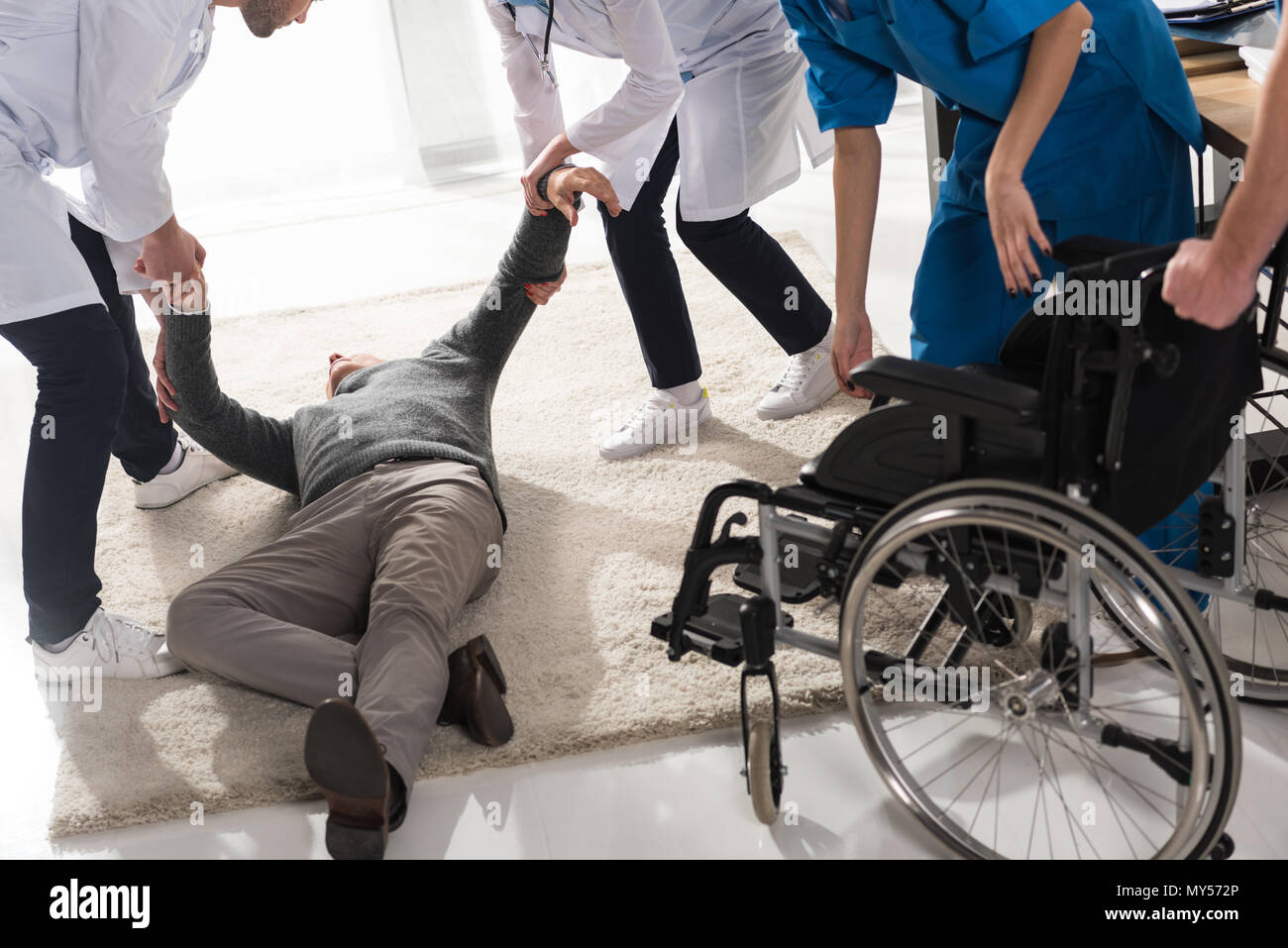 Zugeschnittenes Bild von Ärzten helfen, unbewussten Mann in einem Krankenhaus Stockfoto