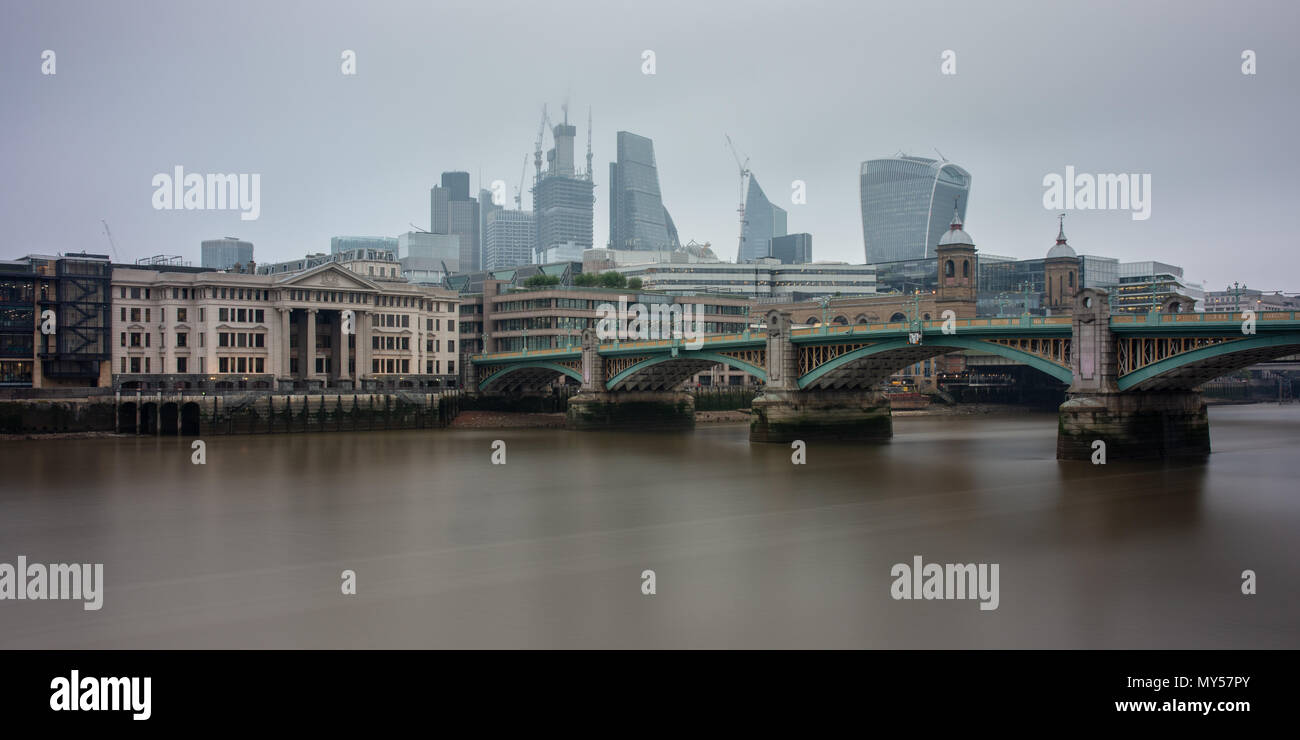 London, England, UK - 29. Mai 2018: Die grauen Himmel und Luftverschmutzung Verkleidung der Stadt Skyline von London über die Themse gesehen neben Southwar Stockfoto