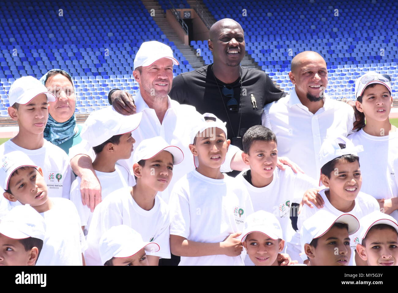 Marrakesch, Marokko. 5. Juni 2018. Ehemaligen deutschen Fußball-Spieler Lothar Matthaeus (4. R, Oben), ehemalige senegalesischer Fußballspieler Khalilou Fadiga (3. R, Oben) und der ehemalige brasilianische Fußballspieler Roberto Carlos (2. R, Oben) posieren für Fotos mit Kindern während ihres Aufenthalts in einem Stadion in Marrakesch, Marokko, 5. Juni 2018. Lothar Matthaeus, Roberto Carlos und Khalilou Fadiga sind Botschafter für Marokko 2026 Wm-Angebot. Credit: Aissa/Xinhua/Alamy leben Nachrichten Stockfoto